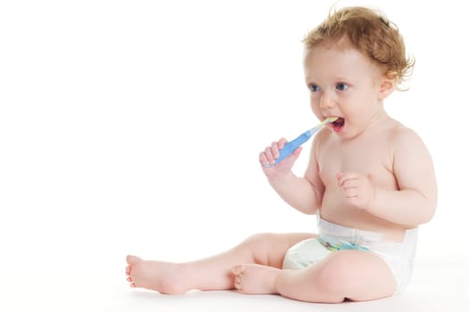 Cute baby in diaper brushes her own teeth