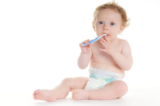Cute baby in diaper brushes her own teeth