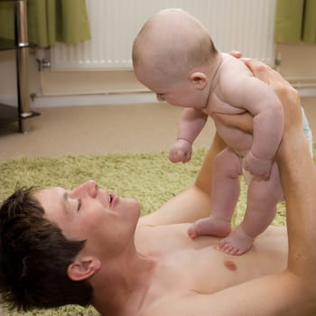 Young first time father playing with baby son.