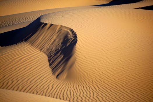 Sand dunes in daylight with shadows. Concept for holidays and traveling.