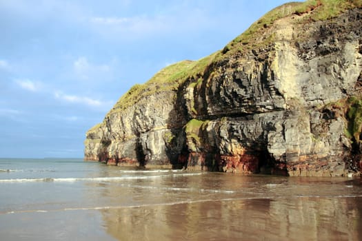 a view of the beach cliffs in ballybunion co kerry ireland with reflection