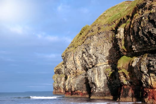 a view of the beach cliffs in ballybunion co kerry ireland with gulls flying