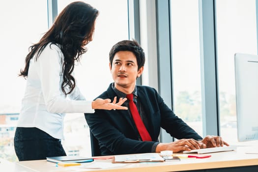 Two business people talk project strategy at office meeting room. Businessman discuss project planning with colleague at modern workplace while having conversation and advice on financial report. Jivy