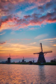 Netherlands rural lanscape with windmills at famous tourist site Kinderdijk in Holland on sunset with dramatic sky