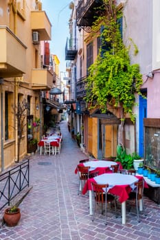 Street cafe in scenic picturesque streets of Chania venetian town with coloful old houses. Chania greek village in the morning. Chanica, Crete island, Greece