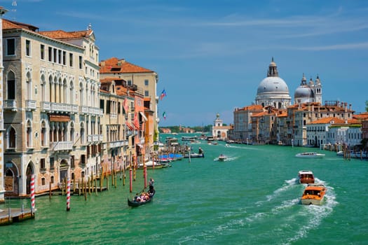 VENICE, ITALY - JULY 19, 2019: View of Venice Grand Canal with boats and Santa Maria della Salute church in the day from Ponte dell'Accademia bridge. Venice, Italy