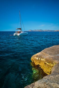 Yacht boat in Aegean sea at white rocks of Sarakiniko Beach, Milos island , Greece