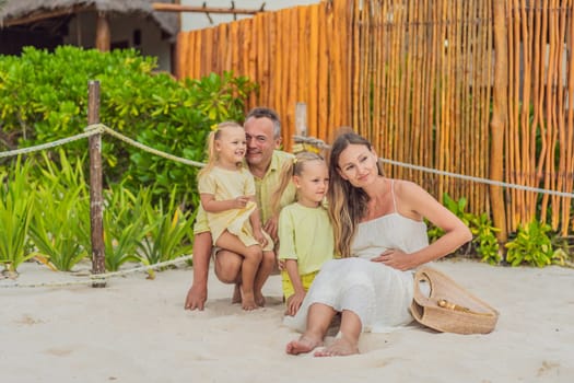 A joyful family, two girls, dad, and a pregnant mom, bask in tropical beach bliss, celebrating a radiant pregnancy amidst paradise.