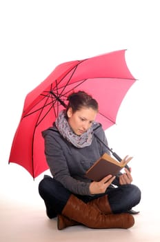 Young woman reading under the umbrella