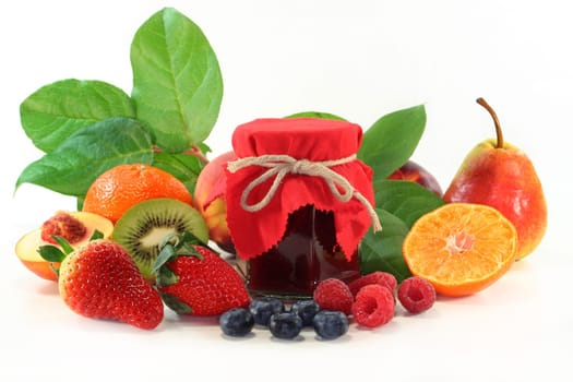 a jar of jam and fresh fruits against a white background