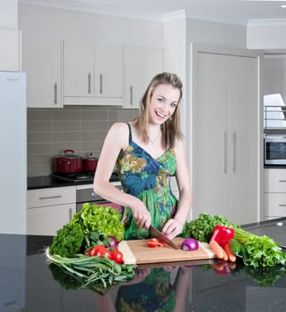 pretty young woman chopping and preparing vegetables