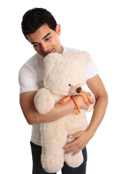 A man cuddling a teddy bear.  White background.