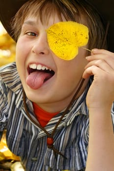 Happy boy playing mischievously in the autumnal fall.  400iso