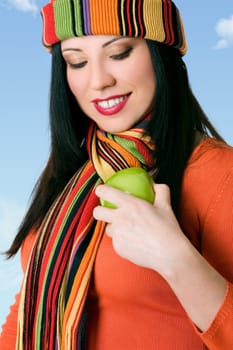 A female buffs a fresh green apple to make it shiny.