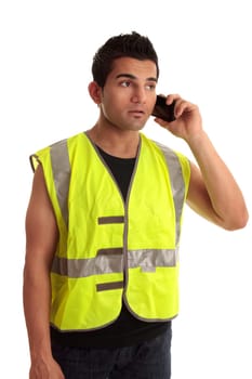 Construction worker in safety vest receives a call on a mobile phone.