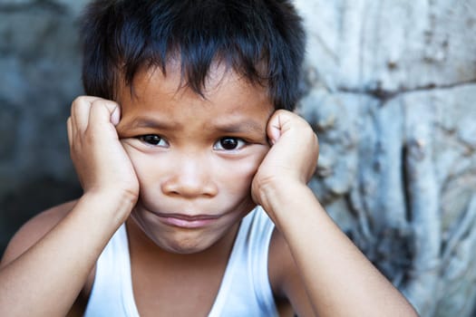 Young Asian male against wall - Poverty in the Philippines