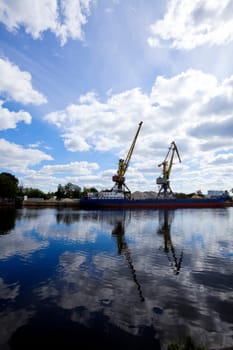 crane silhouette on dock and mirror river