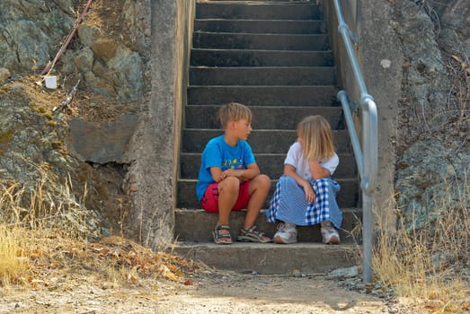 brother and sister sit on the steps