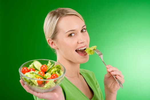 Healthy lifestyle - woman holding vegetable salad on green background