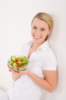 Healthy lifestyle - smiling woman with vegetable salad on white