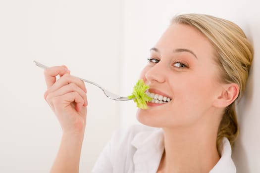 Healthy lifestyle - young woman with lettuce on white background