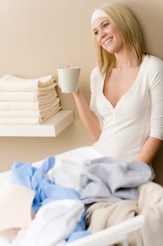 Laundry ironing - woman break with drink after housework