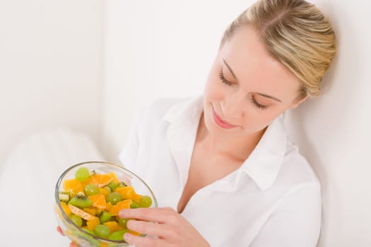 Healthy lifestyle - woman holding bowl with fruit salad on white background