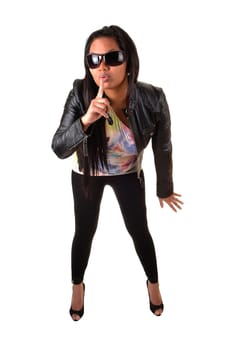 An Asian woman in a black leather jacket and tights, with sunglasses holds her finger for her mouth, be quiet, for white background.