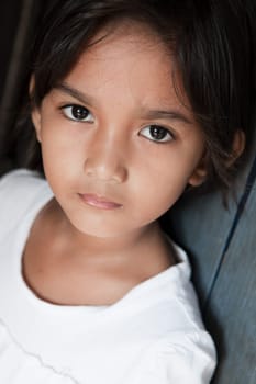 Portrait of a pretty young girl from the Philippines against a wall