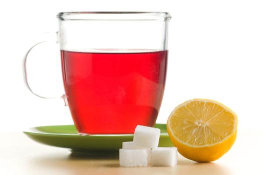 Transparent tea cup with red tea,lemon and sugar