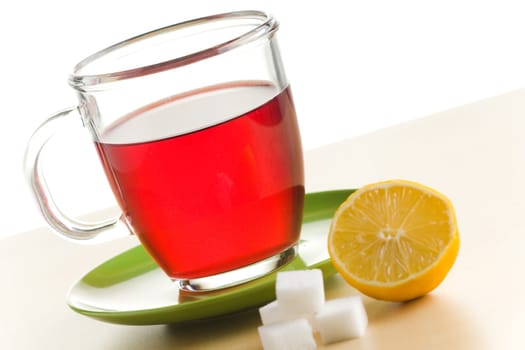 Transparent tea cup with red tea,lemon and sugar