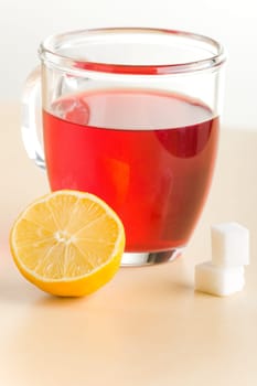 Transparent tea cup with red tea,lemon and sugar