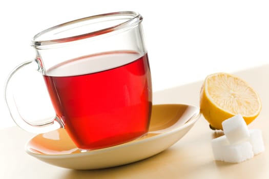 Transparent tea cup with red tea,lemon and sugar