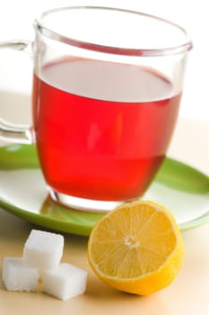 Transparent tea cup with red tea,lemon and sugar