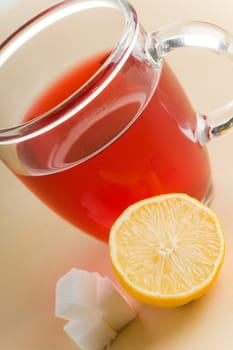 Transparent tea cup with red tea,lemon and sugar