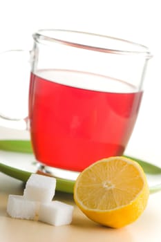 Transparent tea cup with red tea,lemon and sugar