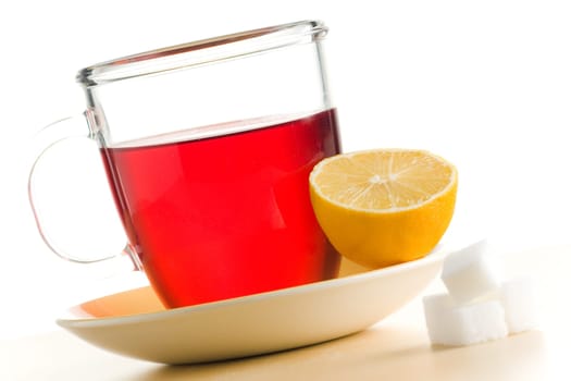 Transparent tea cup with red tea,lemon and sugar