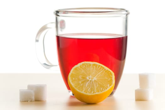 Transparent tea cup with red tea,lemon and sugar