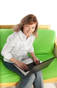 Young blond pretty woman sitting on sofa with laptop computer  isolated on white