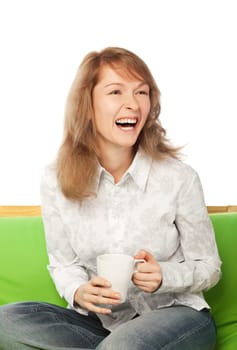 Laughing young blond woman sits on sofa  isolated on white