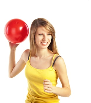 Pretty smiling young blond woman in sportive cloths holding red ball