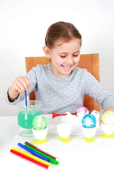 Cute little girl painting Easter eggs