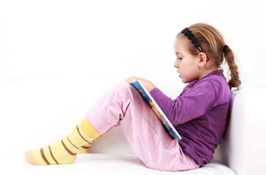 Cute little girl reading a book