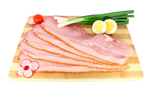 Pork ham on wooden board with some vegetables isolated on white