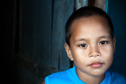 Portrait of an Asian child - Filipino boy by wall in natural light