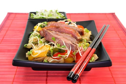 crispy duck breast with fried noodles and vegetables