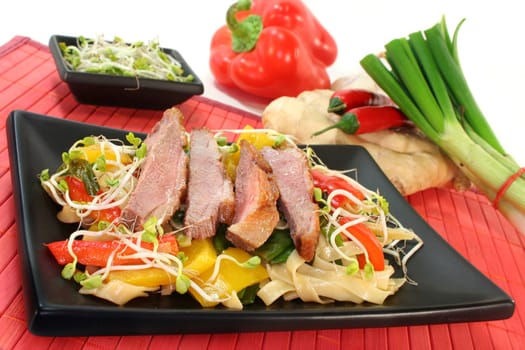 crispy duck breast with fried noodles and vegetables