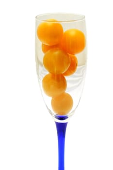 Glass is filled by yellow tomatoes isolated