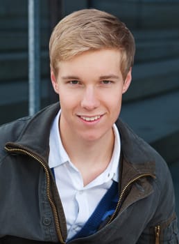 Portrait of smiling blond handsome young man outdoors
