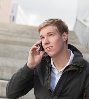 Young blond handsome man speaking on his mobile phone